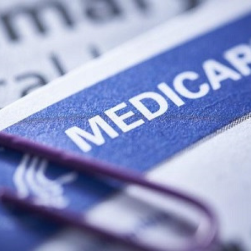 Poster with a closeup of a white and blue Medicare card