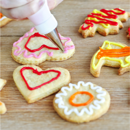 Various decorated cookies; one cookie in the process of being decorated