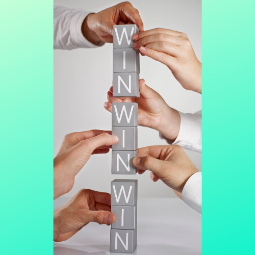 Hands stacking letter blocks to spell win 