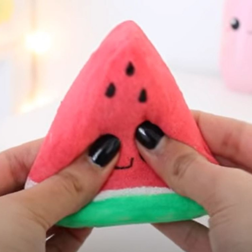 Hands squeezing a watermelon-shaped squishy