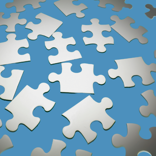 Medium blue background with assorted light gray puzzle pieces scattered about