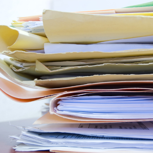 Close up image of a stack of papers in folders looking messy