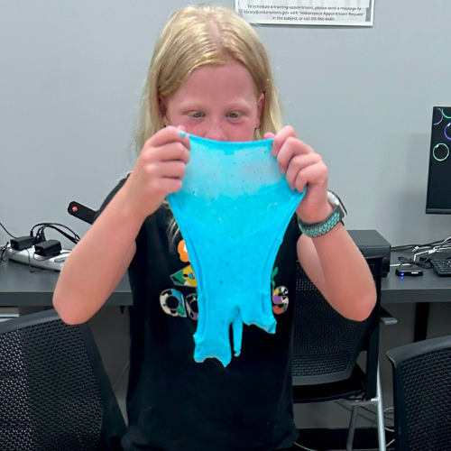 Kid holding up stretchy blue slime