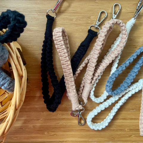 Image of different macramé keychains next to a basket of macramé cord.