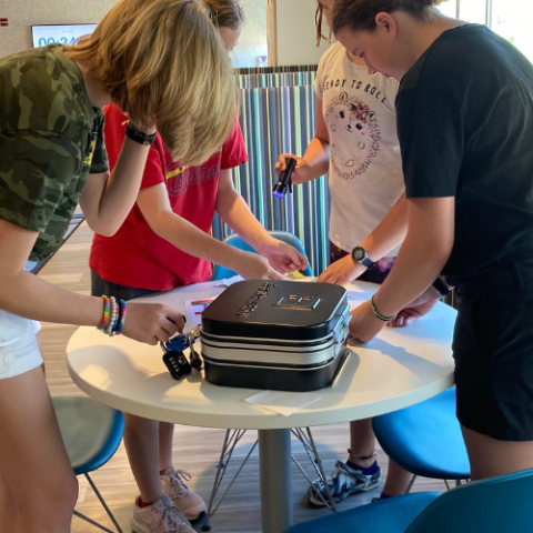 Kids gathered around Breakout Box, trying locks