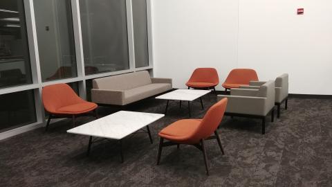 Image of Lounge B with loveseat, two coffee tables, and five lounge-style chairs.