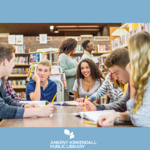 Group of teens talking around a table in a library