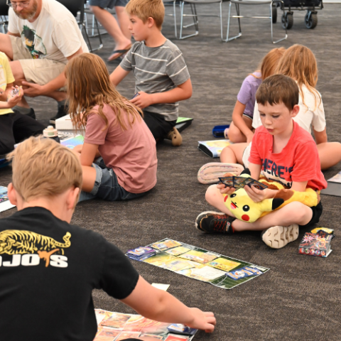 Kids share trading cards with each other. 