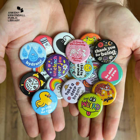 Two hands holding a group of  colorful buttons