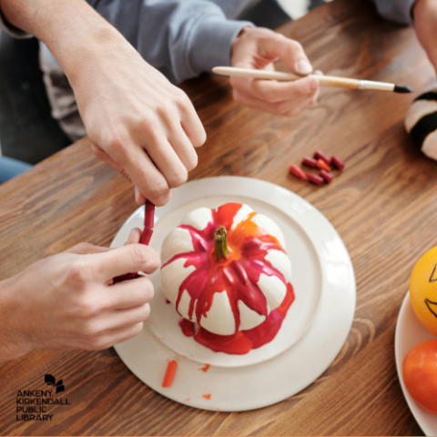 White painted pumpkin with streaks of red and orange paint