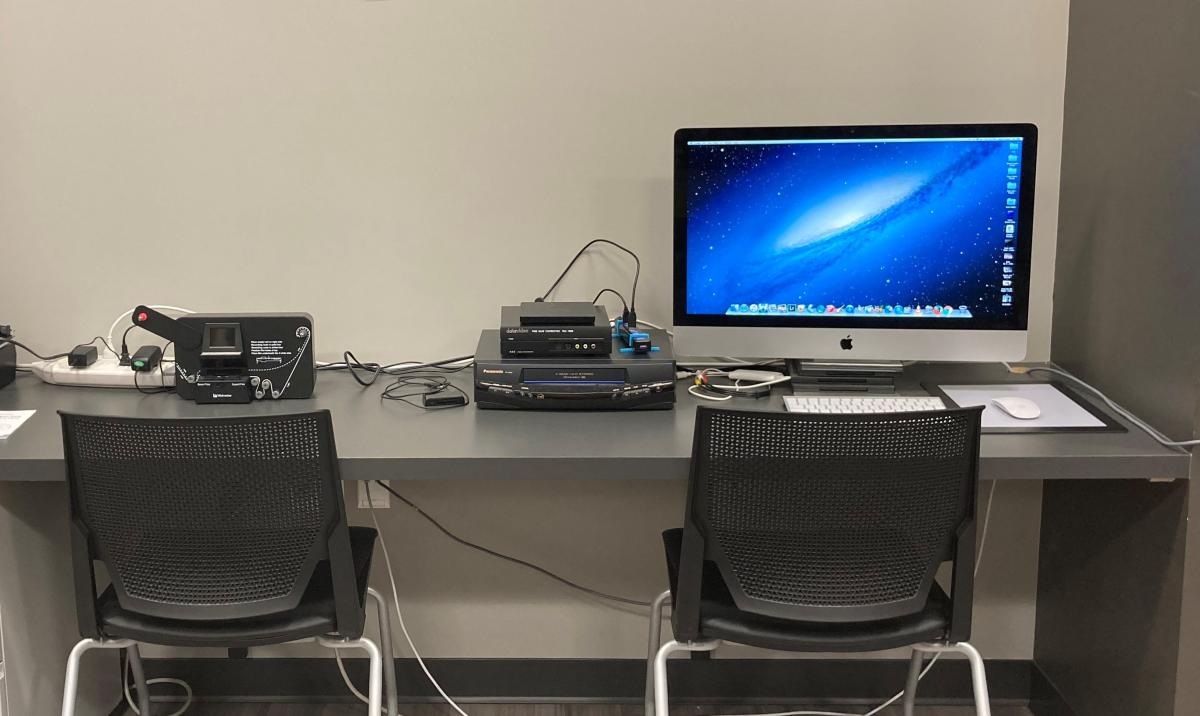 Table with computer, VCR, and Reel-to-Reel conversion machine