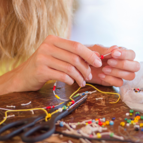 Closeup of a person stringing beads