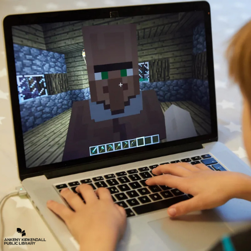 A young boy playing minecraft on a laptop