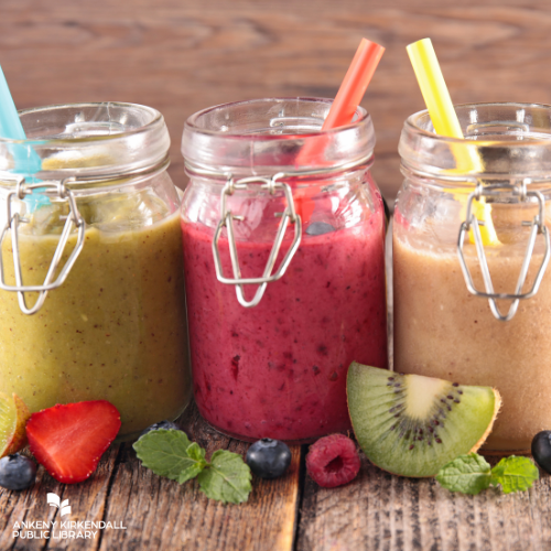 A green smoothie, a pink smoothie, and a brown smoothie with berries next to them