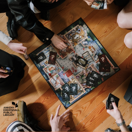 A group of people playing a board game on a wooden floor